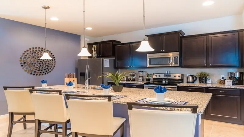 Private kitchen – A modern kitchen with dark cabinets, stainless steel appliances, and a central island with chairs.