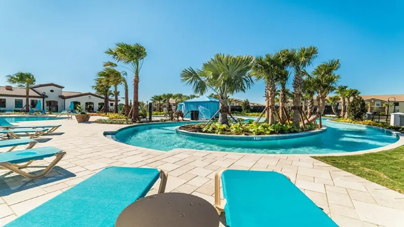 Lazy River, just wonderful ! – A pool area with lounge chairs and palm trees.